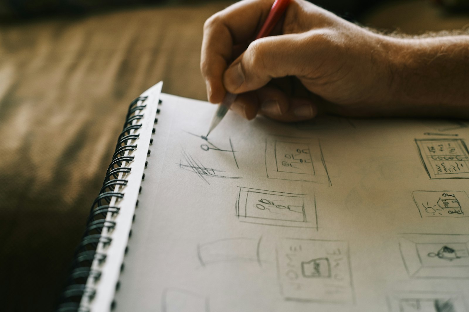 リング綴じのノートに、鉛筆で四角い枠の図をいくつも描いて整理している手元